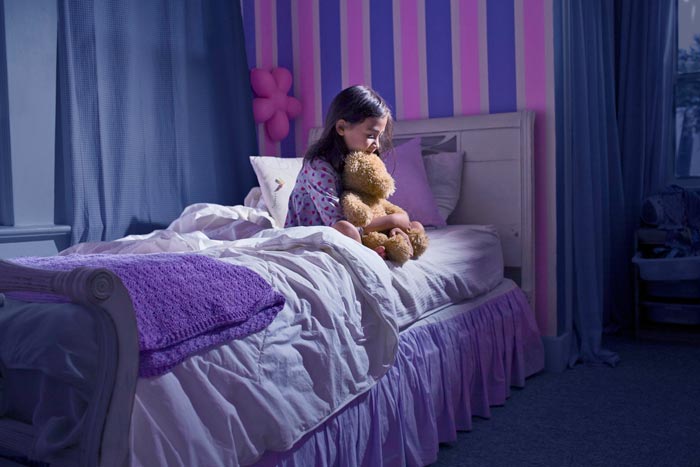 ребенок сидит на кровати