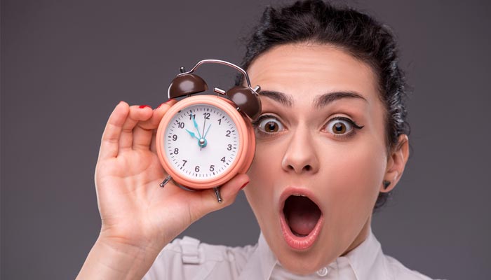 девушка держит будильник